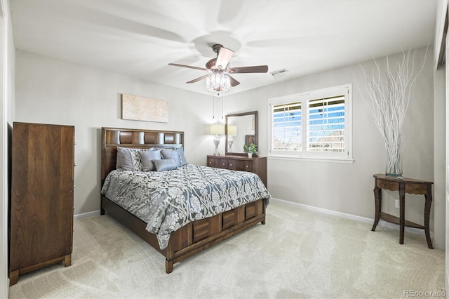 bedroom featuring a ceiling fan, visible vents, light carpet, and baseboards