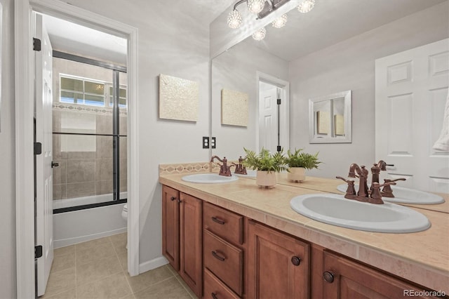 full bath with tile patterned floors, a sink, toilet, and double vanity