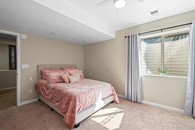 bedroom with baseboards, a ceiling fan, visible vents, and light colored carpet