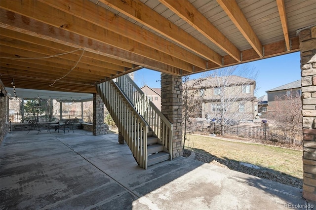 view of patio / terrace featuring fence and stairway