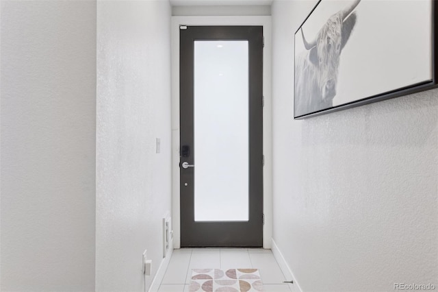 1836 Grove St Unit 108, Denver, CO 80204 - doorway with baseboards, light tile patterned floors, and a textured wall