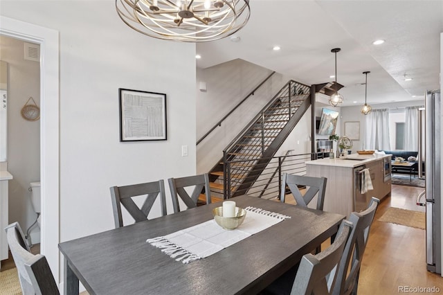 1836 Grove St Unit 108, Denver, CO 80204 - dining area featuring wood finished floors, a chandelier, recessed lighting, and stairs