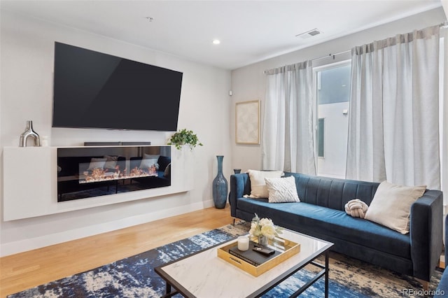 1836 Grove St Unit 108, Denver, CO 80204 - living area featuring wood finished floors, baseboards, recessed lighting, and a glass covered fireplace