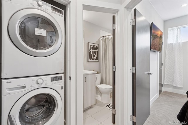 1836 Grove St Unit 108, Denver, CO 80204 - washroom featuring stacked washing machine and dryer and light tile patterned floors