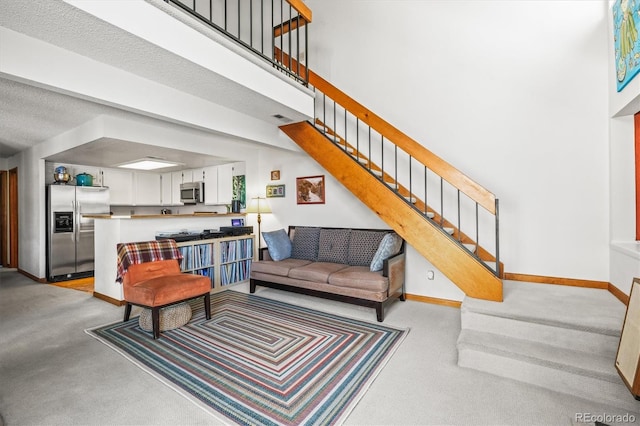 living room featuring a high ceiling and light carpet