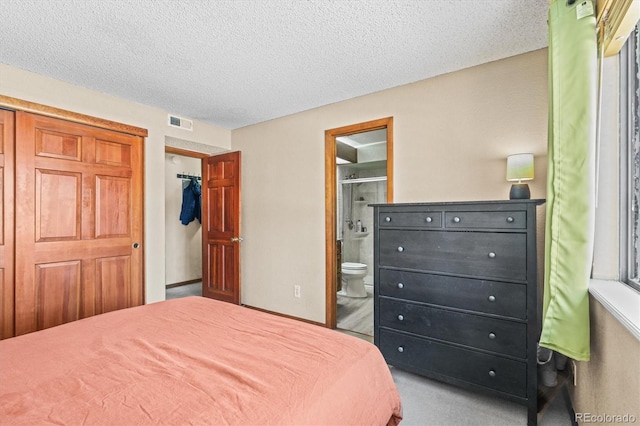 bedroom featuring a textured ceiling and ensuite bathroom