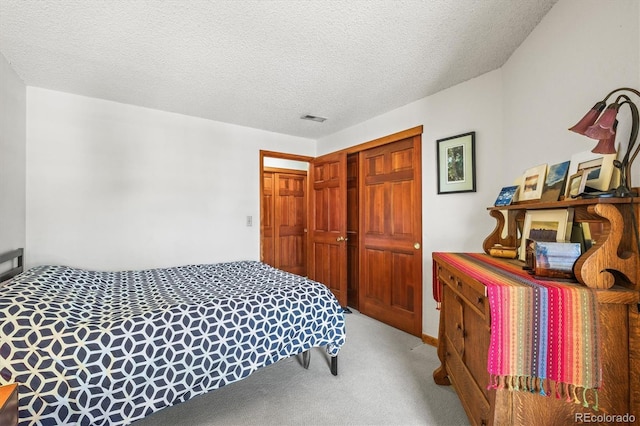 carpeted bedroom with a textured ceiling and a closet