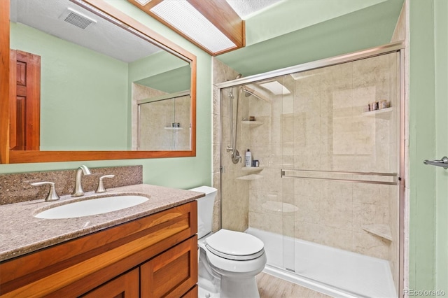 bathroom with vanity, toilet, and walk in shower