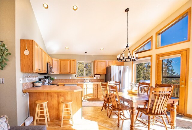 dining area featuring high vaulted ceiling, recessed lighting, and an inviting chandelier