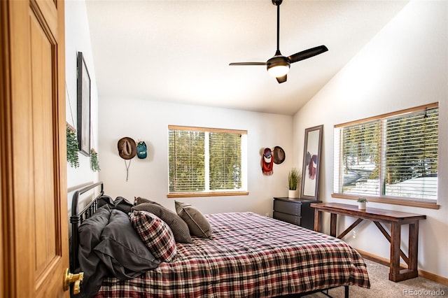 carpeted bedroom with a ceiling fan, multiple windows, vaulted ceiling, and baseboards