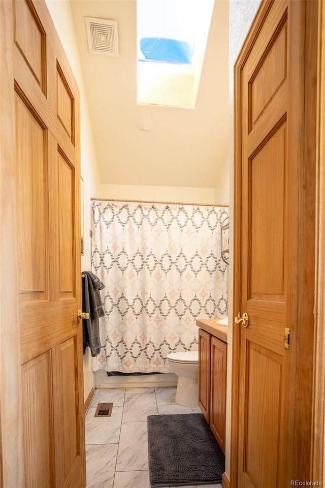 full bathroom with toilet, marble finish floor, vaulted ceiling with skylight, and visible vents