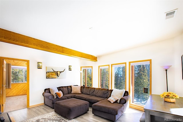 living room featuring baseboards, light wood-style flooring, visible vents, and beam ceiling