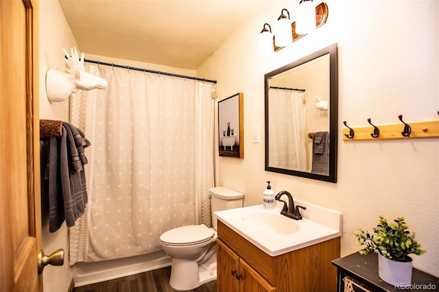 bathroom featuring curtained shower, vanity, toilet, and wood finished floors