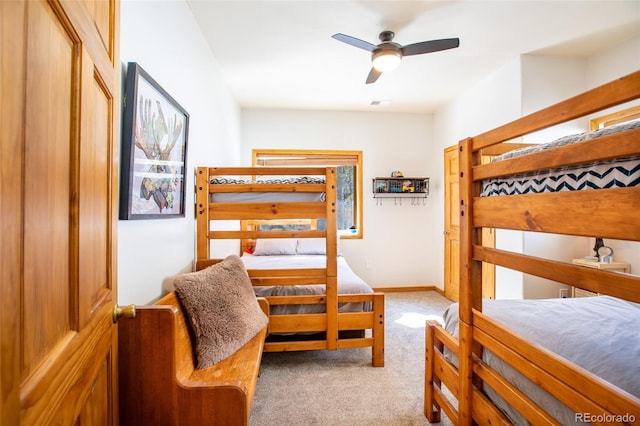 carpeted bedroom with a ceiling fan, visible vents, and baseboards