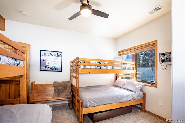 carpeted bedroom featuring baseboards, visible vents, and a ceiling fan