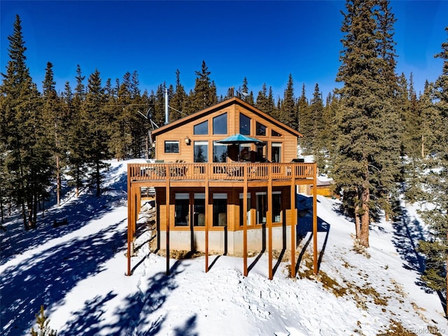 snow covered property with a deck