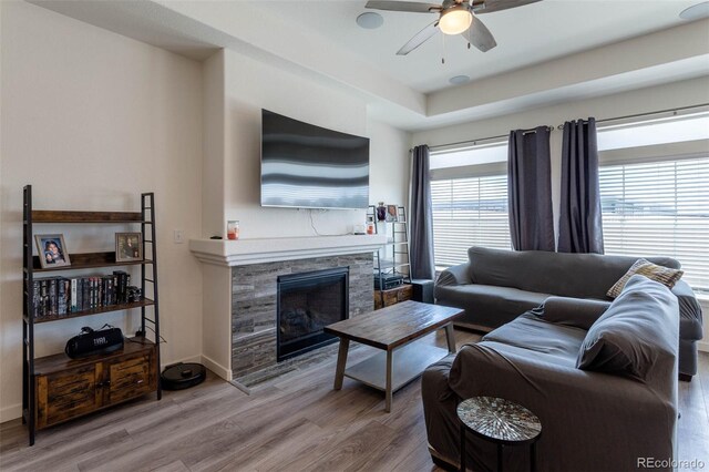 living room featuring a healthy amount of sunlight, hardwood / wood-style floors, ceiling fan, and a tray ceiling