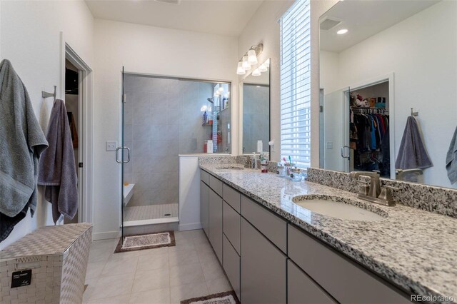 bathroom with an enclosed shower, double sink, tile floors, and large vanity