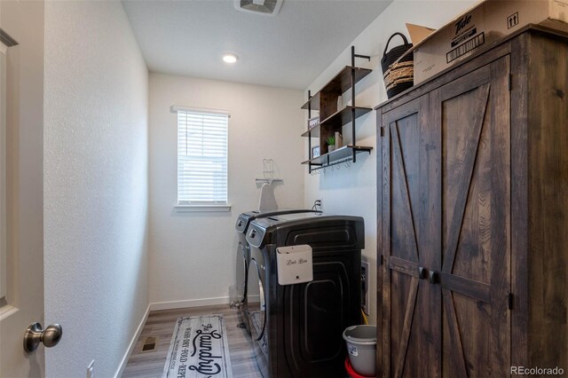 laundry room with washer and dryer and hardwood / wood-style floors