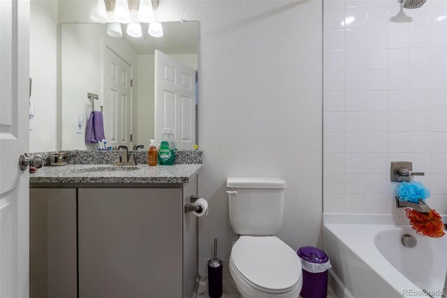 full bathroom with tiled shower / bath, toilet, and vanity