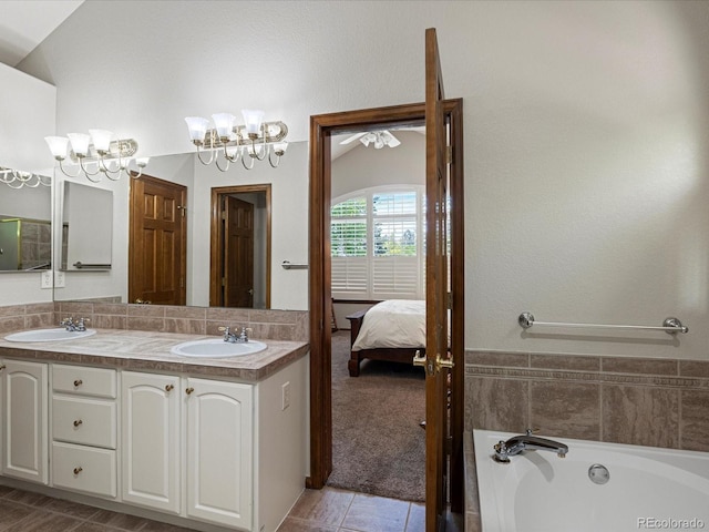 6900 W Grant Ranch Blvd Unit 49, Littleton, CO 80123 - bathroom featuring a chandelier, double vanity, a garden tub, connected bathroom, and tile patterned flooring