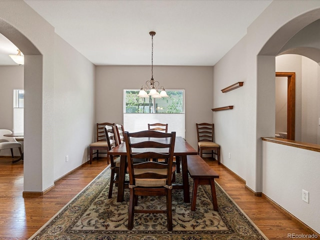 6900 W Grant Ranch Blvd Unit 49, Littleton, CO 80123 - dining area with arched walkways, wood finished floors, and a chandelier