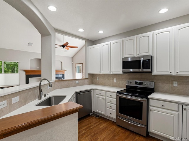6900 W Grant Ranch Blvd Unit 49, Littleton, CO 80123 - kitchen featuring appliances with stainless steel finishes, a sink, decorative backsplash, white cabinetry, and vaulted ceiling