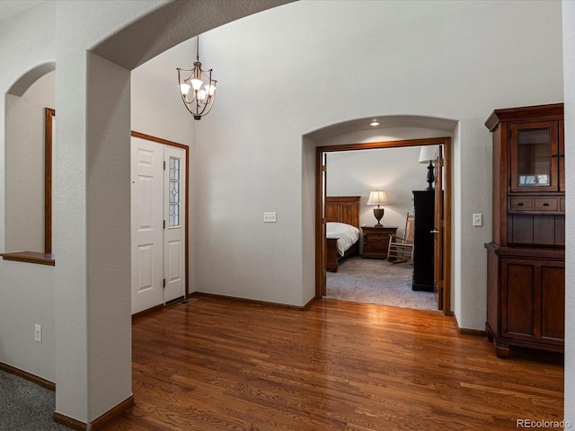 6900 W Grant Ranch Blvd Unit 49, Littleton, CO 80123 - entrance foyer featuring arched walkways, dark wood-type flooring, a chandelier, and baseboards