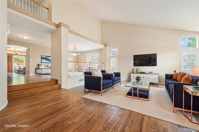 10155 Charissglen Ln, Littleton, CO 80126 - living area with a towering ceiling, wood finished floors, arched walkways, and baseboards