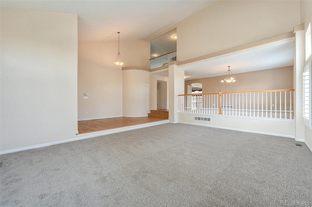 10155 Charissglen Ln, Littleton, CO 80126 - spare room featuring carpet flooring, high vaulted ceiling, baseboards, and a chandelier