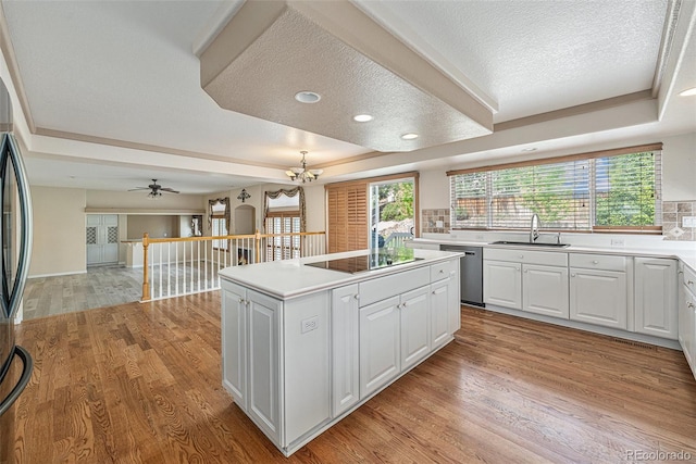 10155 Charissglen Ln, Littleton, CO 80126 - kitchen with a tray ceiling, a sink, a textured ceiling, appliances with stainless steel finishes, and a kitchen island