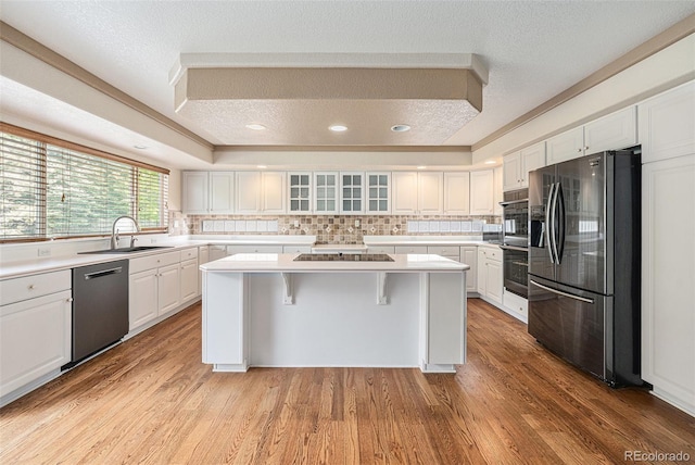 10155 Charissglen Ln, Littleton, CO 80126 - kitchen featuring stainless steel appliances, a sink, a kitchen island, decorative backsplash, and a raised ceiling