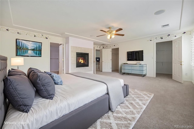 10155 Charissglen Ln, Littleton, CO 80126 - bedroom with light colored carpet, baseboards, a tiled fireplace, and a ceiling fan