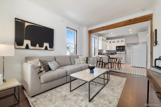 living room with beam ceiling and wood-type flooring