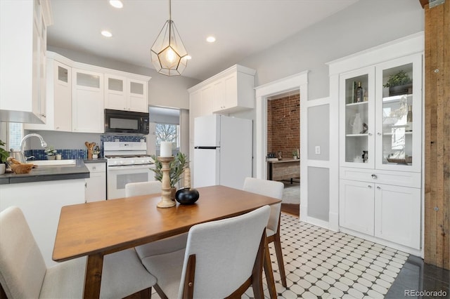 kitchen with white cabinetry, white appliances, sink, and hanging light fixtures