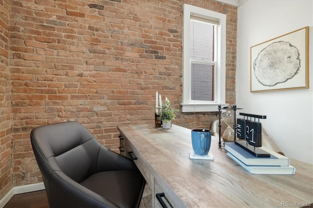 office area featuring hardwood / wood-style floors and brick wall