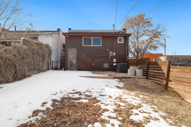 snow covered rear of property with central AC