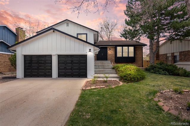 view of front of house featuring a lawn, brick siding, board and batten siding, concrete driveway, and an attached garage
