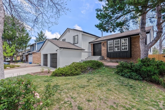 tri-level home featuring concrete driveway, brick siding, an attached garage, and a front lawn
