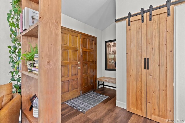 entrance foyer with baseboards, a barn door, and wood finished floors