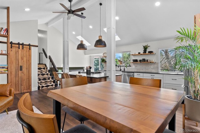 dining area featuring plenty of natural light, a ceiling fan, dark wood-style flooring, and beam ceiling