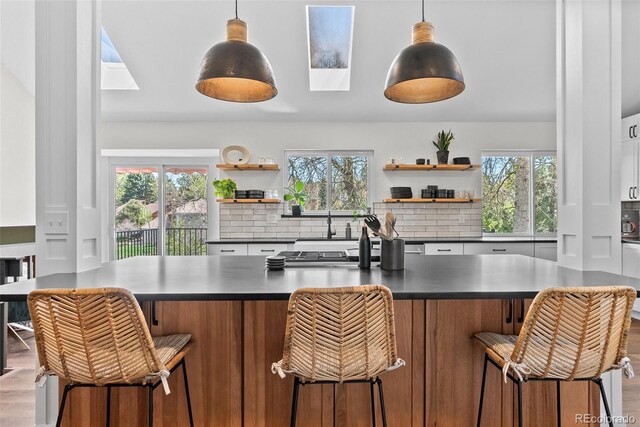 kitchen featuring dark countertops, open shelves, and a wealth of natural light