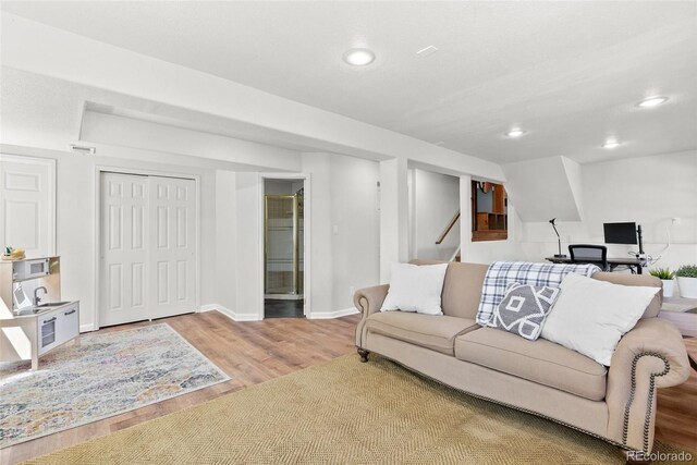living area with stairs, recessed lighting, baseboards, wood finished floors, and visible vents