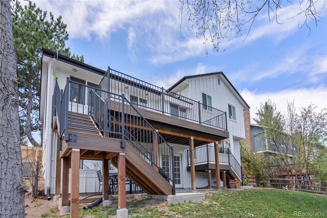 rear view of property featuring stairs, a wooden deck, a yard, and fence