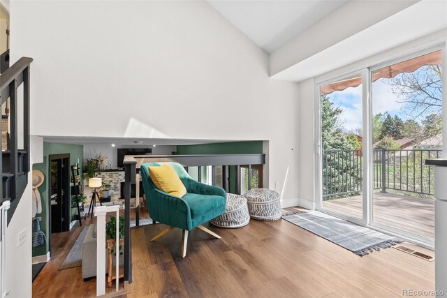 living area with high vaulted ceiling and wood finished floors