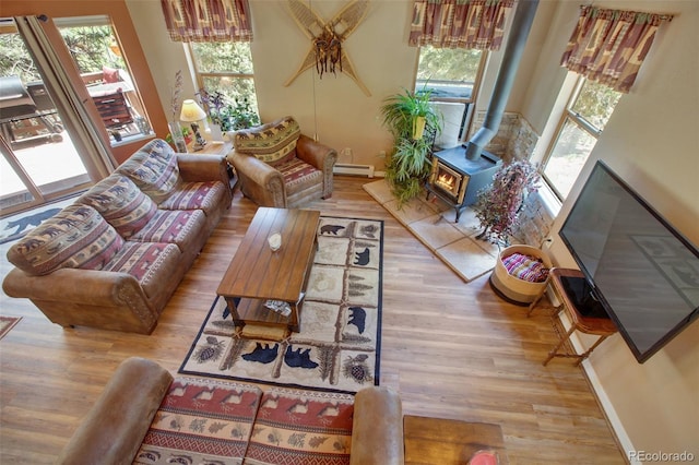 living room with a wood stove, plenty of natural light, and light wood-type flooring