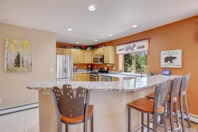 kitchen featuring a kitchen bar, light stone countertops, stainless steel appliances, a baseboard heating unit, and sink