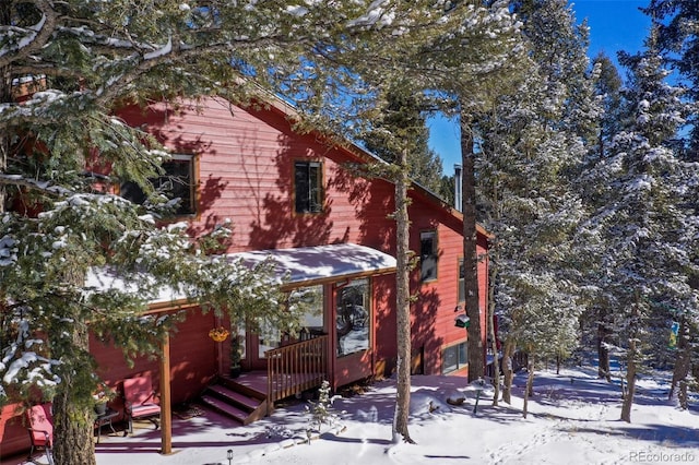 view of snow covered exterior with a wooden deck