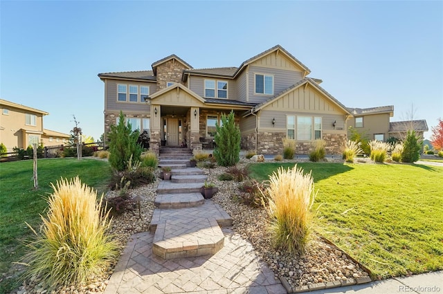 craftsman inspired home featuring stone siding, a front lawn, and board and batten siding