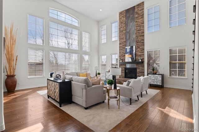 living room featuring wood-type flooring, a fireplace, and baseboards